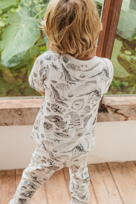 This piece of prehistory is made for adventurer. The wide cut sleeves are great for maximum movement during play. It also features a chest pocket. Inspired by the beautiful prehistoric illustration by Tattoo-Artist Suflanda the T-shirts showing many kinds of dinosaurier and flora and fauna from past times.